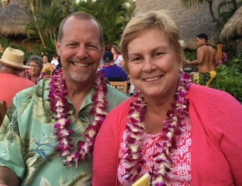 Bone Marrow Transplant patient, Lynne Grunthaner, wears a flower lei as she smiles for a photo.