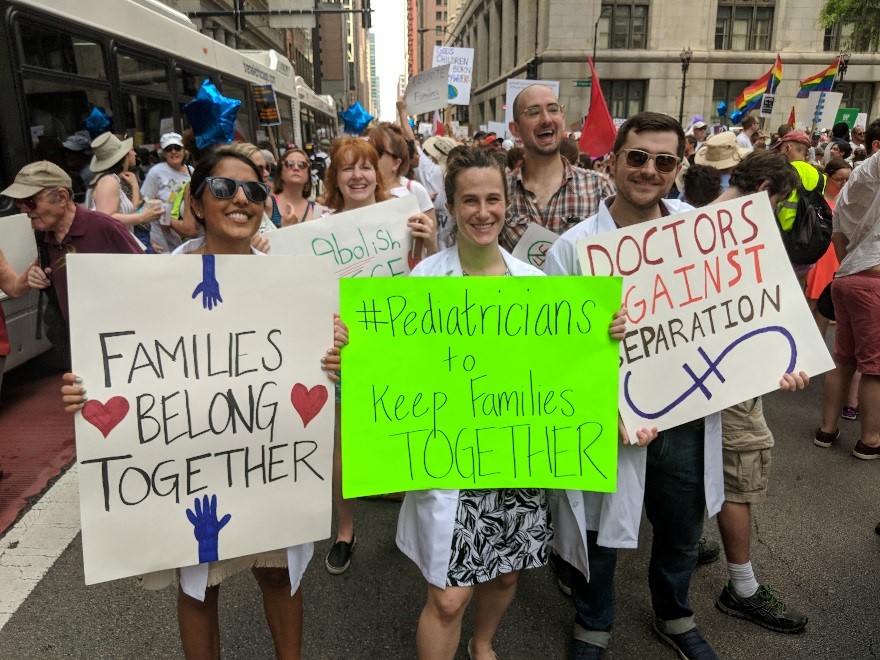 people holding signs and advocating for keeping families together