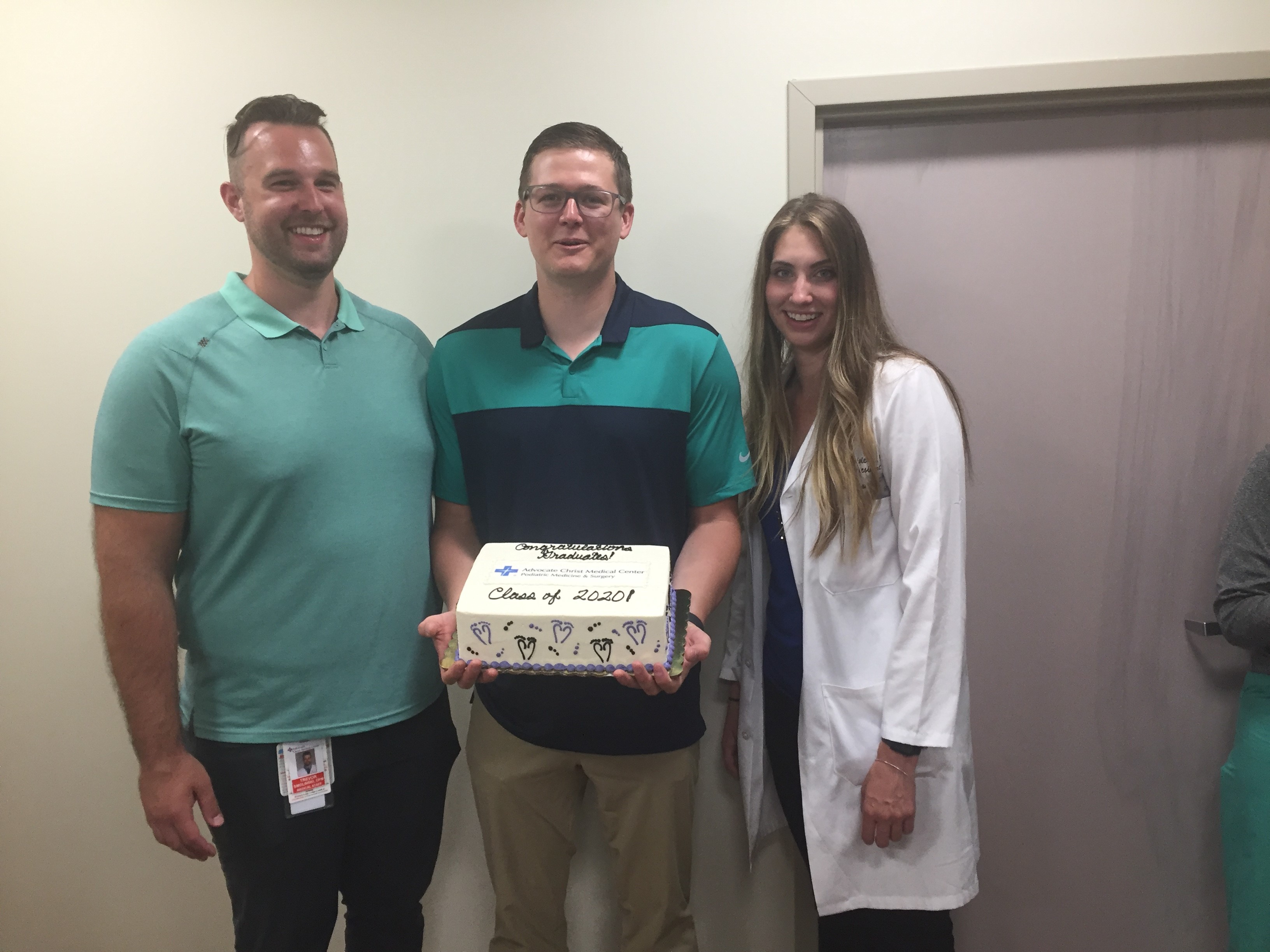 graduates holding a cake