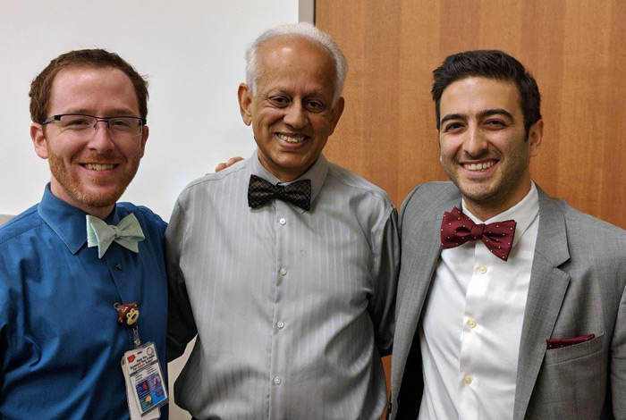 Three men in bowties smile at the camera