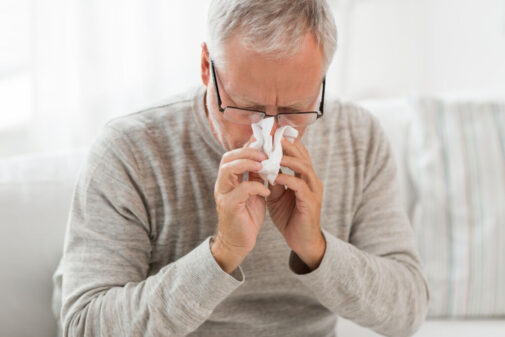 Older person blowing nose