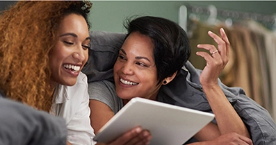 Two people looking at a device laughing